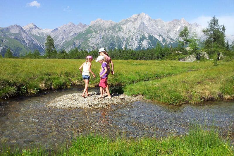 Kinder spielen am Bach